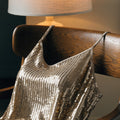 Unbranded gold sequin cami draped over a bedroom chair (product image, invented unbranded)