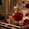 Empress Red Gilded-Crown Lacquer – red apple-shaped lacquer bottle with gilded crown cap on mirrored tray with rose petals