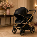 Gilded Crown Midnight Travel Pram – black-and-gold pram with small crown emblem in elegant hallway