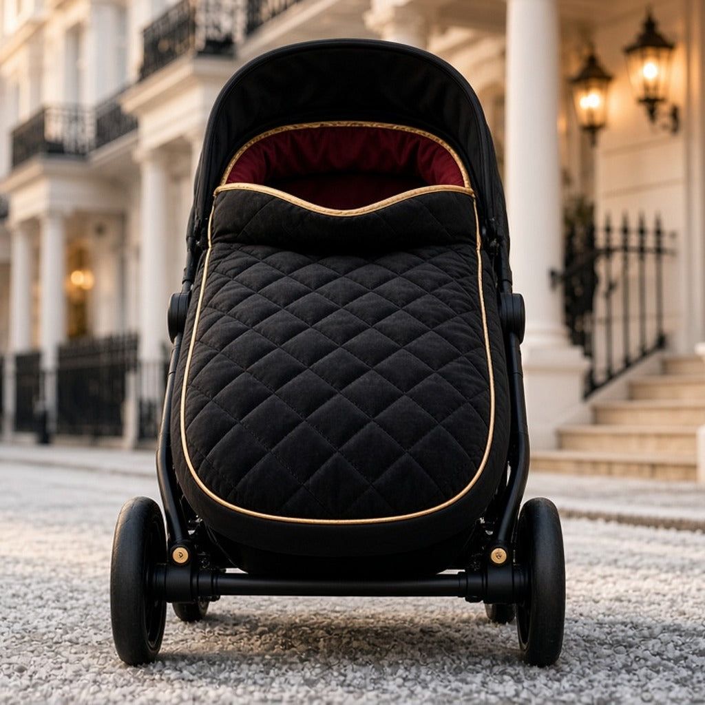 Gilded Midnight Pram Footmuff – black quilted footmuff with gold piping in black pram on street